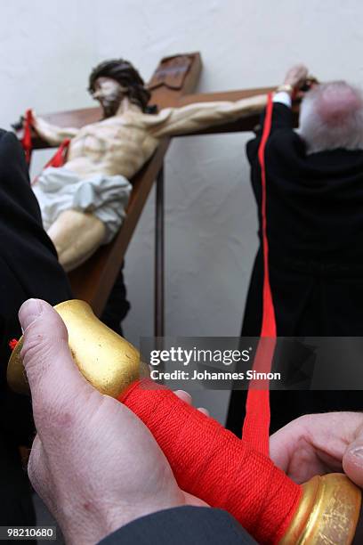 Members of the town's crafts guilds decorate a baroque sculpture Christ hanging on the cross during a Good Friday procession on April 2, 2010 in Lohr...