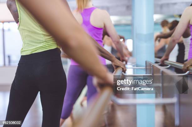 women doing barre workout together at modern gym - pike position stock pictures, royalty-free photos & images