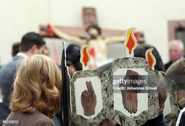 Little boys carry signs depicting the stigmata of Christ ahead of a Good Friday procession on April 2, 2010 in Lohr am Main, Germany. Several...