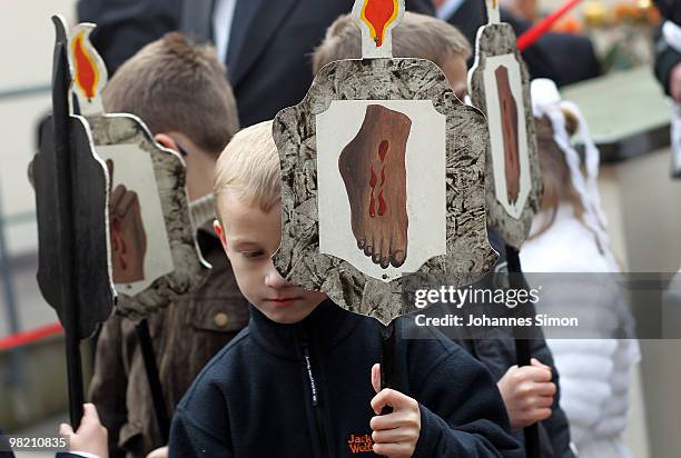 Little boys carry signs depicting the stigmata of Christ ahead of a Good Friday procession on April 2, 2010 in Lohr am Main, Germany. Several...