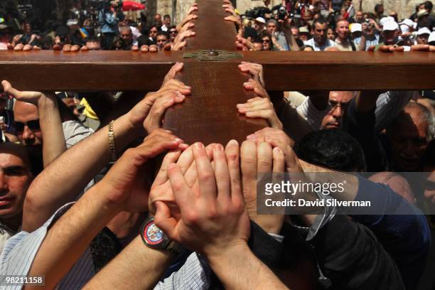 Palestinian Christians carry their large wooden cross along the Via Dolorosa, the route tradition says Jesus carried the cross on which he was to be...