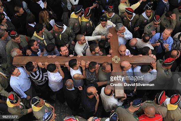 Palestinian Christians carry their large wooden cross along the Via Dolorosa, the route tradition says Jesus carried the cross on which he was to be...