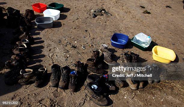 Shoes are lined up on the beach as the Northern Cross pilgrimage makes its final leg of the journey to Holy Island on April 2, 2010 in...