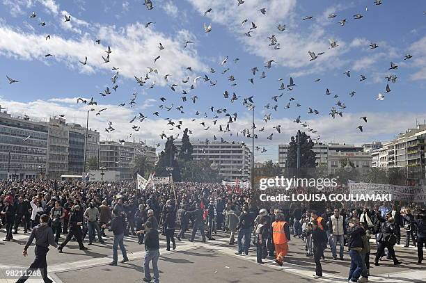 Demonstrators escape the tear gas thrown by police in front of the Greek parliament in Athens on March 5, 2010. Greece has frozen pensions and raised...