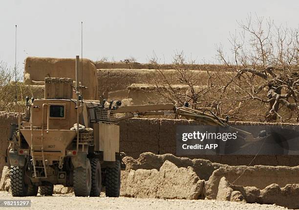Army vehicle moves an improvised explosive device with a remote arm on a main road in Yosef Khel district of Paktika province on April 2, 2010....