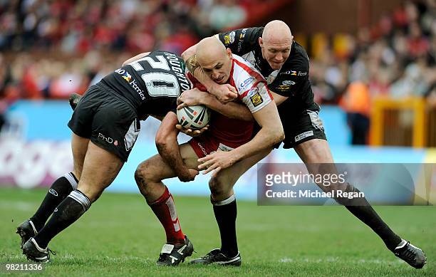 Danny Houghton and Craig Fitzgibbon of Hull FC tackle Mick Vella of Hull KR during the engage Super League match between Hull Kingston Rovers and...
