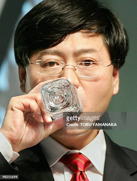 Yang Yuanqing, chairman of Lenovo Group, drinks some water as he delivers a speech in front of Japanese businessmen under a theme of "Innovation that...