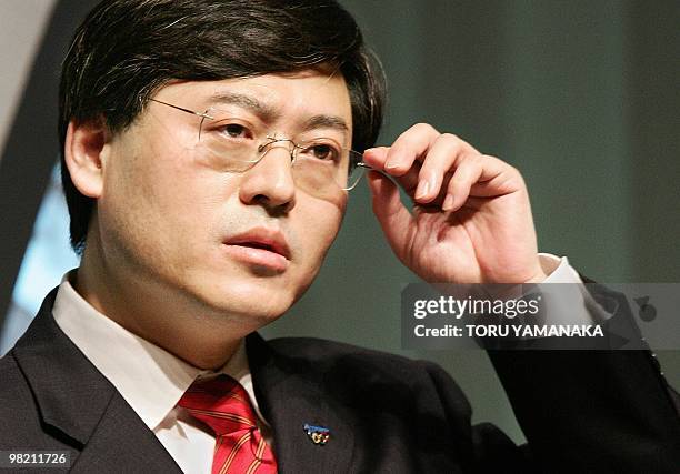 Yang Yuanqing, chairman of Lenovo Group, adjusts his glasses as he delivers a speech in front of Japanese businessmen under a theme of "Innovation...