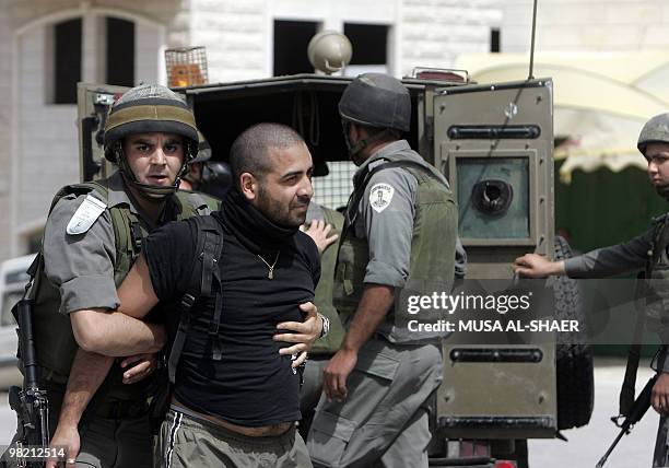 Israeli soldiers arrest a demonstrator during a protest by Palestinians and foreign peace activists against Israel's controversial separation barrier...