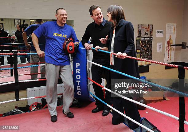 Conservative Party Leader David Cameron and his wife Samantha Cameron speak with boxing instructor Simon Lewin during a visit to the Pedro Club in...