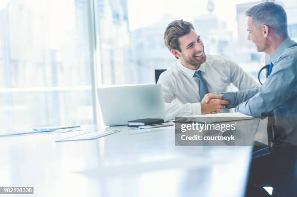two businessmen meeting with technology. - confident businessman sitting with colleagues in office stock pictures, royalty-free photos & images