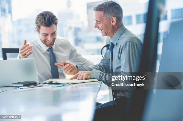 2 businessmen smiling and happy in a meeting. - mature men laughing stock pictures, royalty-free photos & images