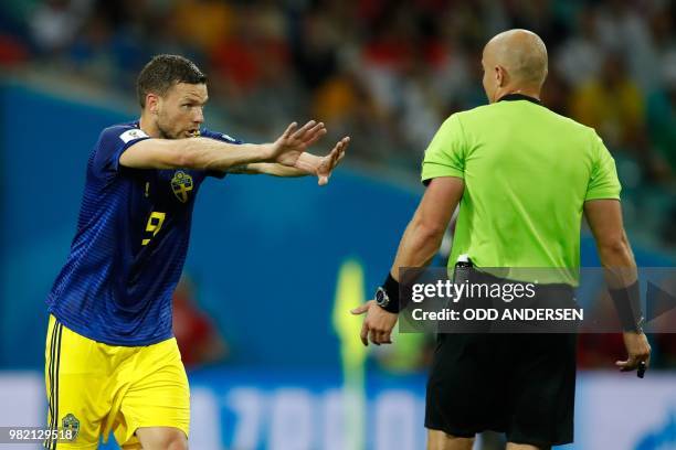 Sweden's forward Marcus Berg gestures as he speaks with Polish referee Szymon Marciniak after failing to score during the Russia 2018 World Cup Group...