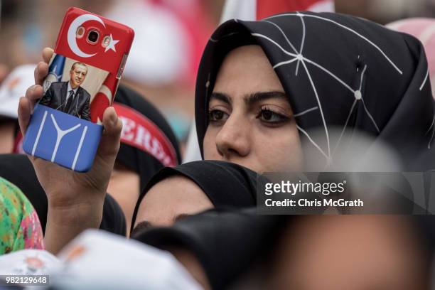 Woman holds up her phone with the image of Turkey's President Recep Tayyip Erdogan ahead of an AK Parti election rally in Eyup on June 23, 2018 in...