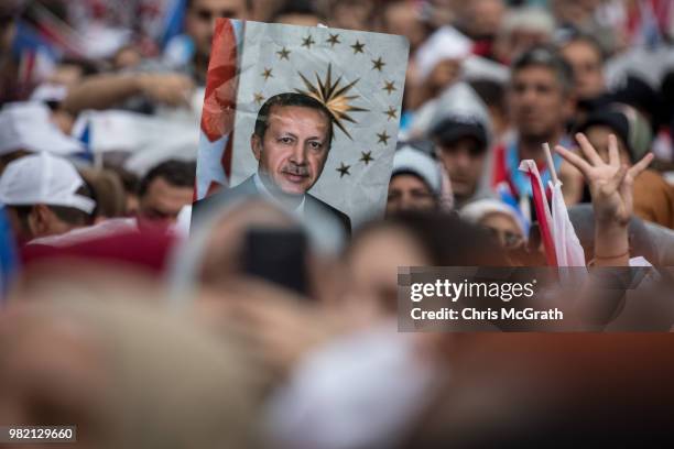 Supporters hold up a poster of Turkey's President Recep Tayyip Erdogan ahead of his arrival during a AK Parti election rally in Eyup on June 23, 2018...