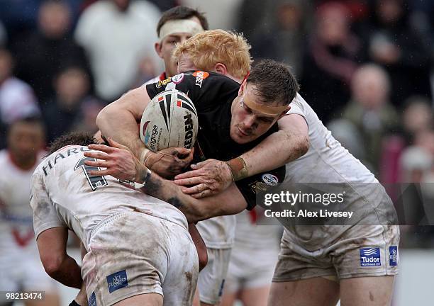 Paul Prescott of Wigan Warriors is tackled by Bryn Hargreaves and James Graham of St. Helens during the Engage Super League match between St. Helens...