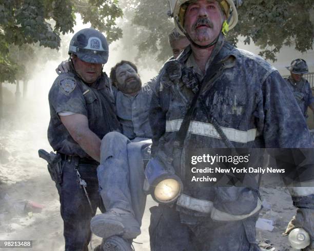 New York Daily News staff photographer David Handschuh is carried from site after his leg was shattered by falling debris while he was photographing...