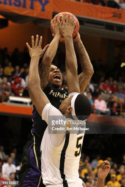 Isaiah Thomas of the Washington Huskies attempts a shot against Kevin Jones of the West Virginia Mountaineers during the east regional semifinal of...