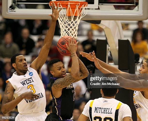 Isaiah Thomas of the Washington Huskies looks to pass the ball as he drives against the West Virginia Mountaineers during the east regional semifinal...