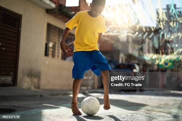 brasilianische kinder spielen fußball auf der straße - favela stock-fotos und bilder