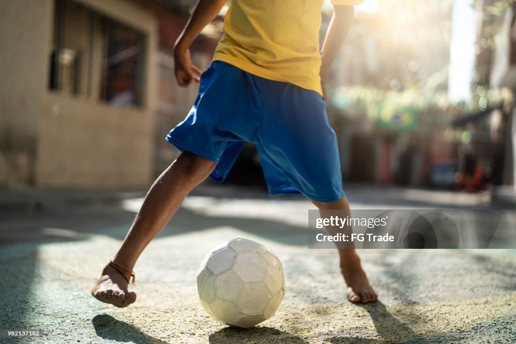 Brazilian Kid Playing Soccer in the Street