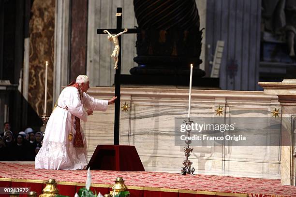 Pope Benedict XVI reaches to the cross as he conducts the Good Friday Passion of The Lord celebration at St. Peter's Basilica on April 2, 2010 in...