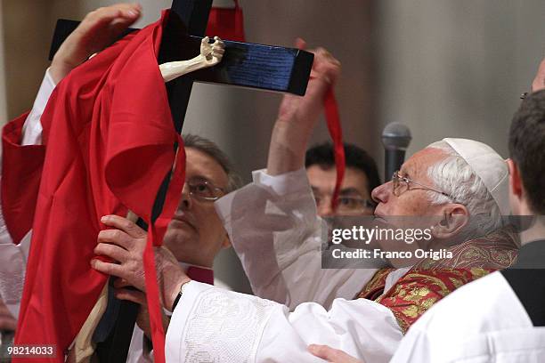 Pope Benedict XVI holds the cross as he conducts the Good Friday Passion of The Lord celebration at St. Peter's Basilica on April 2, 2010 in Vatican...