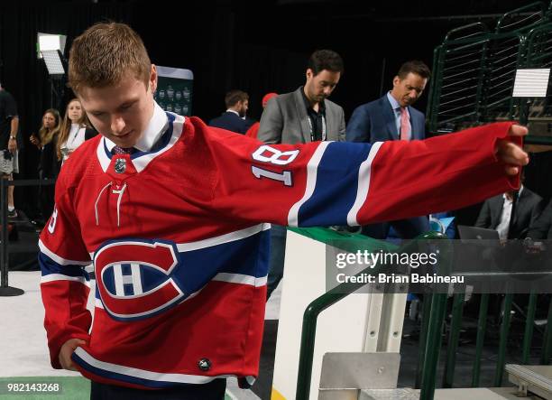 Allan McShane puts on hs jersey after being selected 97th overall by the Montreal Canadiens during the 2018 NHL Draft at American Airlines Center on...