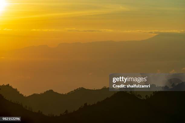 majestic and misty sunrise over mountain range at bromo tengger semeru national park, indonesia. - shaifulzamri - fotografias e filmes do acervo