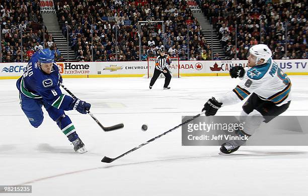 Joe Pavelski of the San Jose Sharks looks on as Sami Salo of the Vancouver Canucks takes a slapshot during the game at General Motors Place on March...