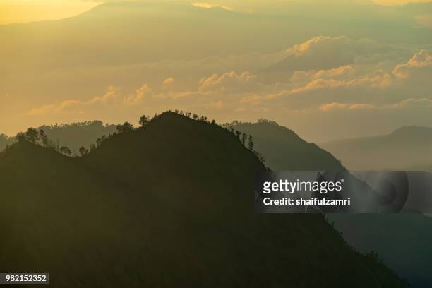 majestic and misty sunrise over mountain range at bromo tengger semeru national park, indonesia. - shaifulzamri - fotografias e filmes do acervo