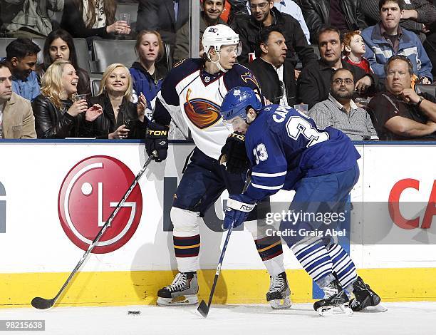 Luca Caputi of the Toronto Maple Leafs battles for the puck with Maxim Afinogenov of the Atlanta Thrashers during the game on March 30, 2010 at the...