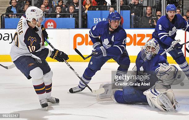 Bryan Little of the Atlanta Thrashers is stopped in close by Jonas Gustavsson of the Toronto Maple Leafs with Tomas Kaberle and Luke Schenn defending...