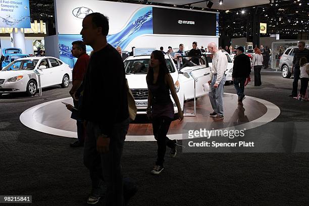 People look at car displays on the opening day of the New York International Auto Show on April 2, 2010 in New York City. The show, which opens to...