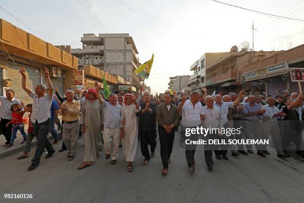 Syrian-Kurdish demonstrators wave Kurdish flag as they protest against demographic changes forced by Turkey to repopulate Kurdish areas, in Qamishli...