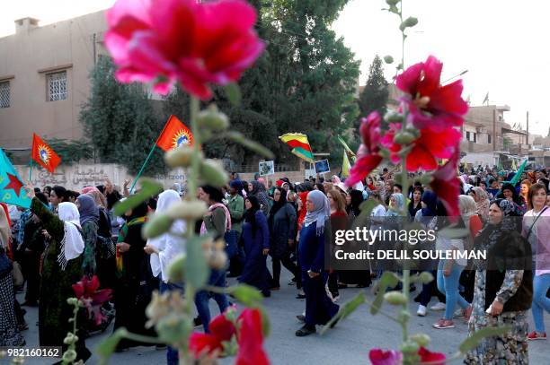 Syrian-Kurdish demonstrators wave Kurdish flag as they protest against demographic changes forced by Turkey to repopulate Kurdish areas, in Qamishli...