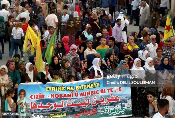 Syrian-Kurdish demonstrators wave Kurdish flag as they protest against demographic changes forced by Turkey to repopulate Kurdish areas, in Qamishli...