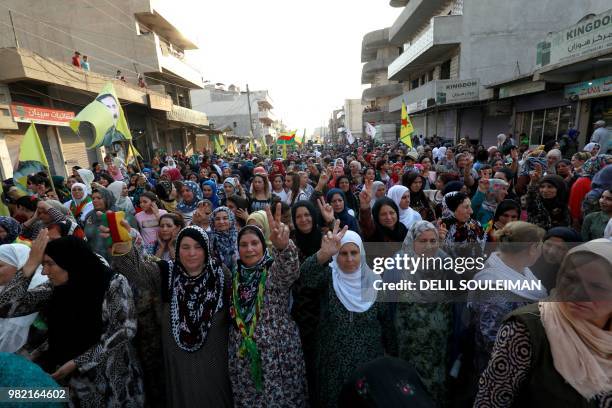 Syrian-Kurdish demonstrators wave Kurdish flag as they protest against demographic changes forced by Turkey to repopulate Kurdish areas, in Qamishli...