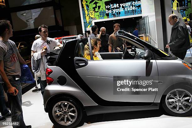 People look at car displays on the opening day of the New York International Auto Show on April 2, 2010 in New York City. The show, which opens to...