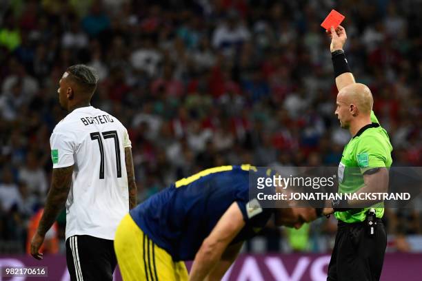 Polish referee Szymon Marciniak presents Germany's defender Jerome Boateng with a red card during the Russia 2018 World Cup Group F football match...