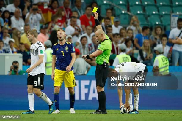 Sweden's midfielder Sebastian Larsson reacts as he receives a yellow card from Polish referee Szymon Marciniak during the Russia 2018 World Cup Group...