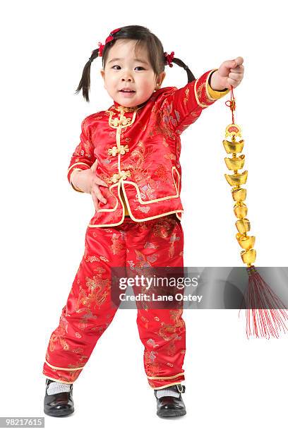 young girl holding chinese new year gold ingot - cheongsam stock pictures, royalty-free photos & images