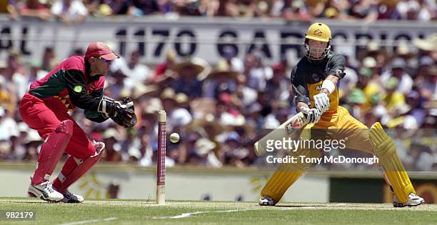 Damien Martyn of Australia cuts through point as wicketkeeper Andy Flower of Zimbabwe looks on during the Carlton Series One Day International...