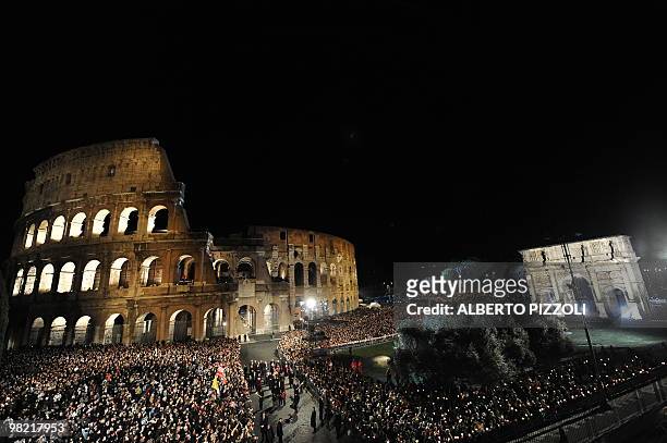 Faithful carry the Cross during one of the station of the Way of the Cross on Good Friday on April 2, 2010 at Rome's Colosseum. AFP PHOTO / ALBERTO...
