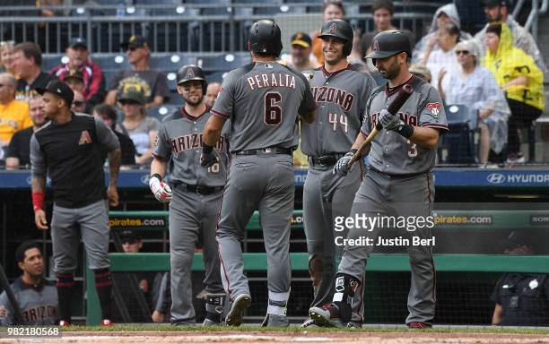 David Peralta of the Arizona Diamondbacks is greeted by Paul Goldschmidt and Daniel Descalso after hitting a triple. A throwing error by Sean...
