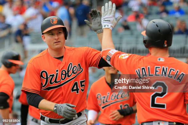 Mark Trumbo of the Baltimore Orioles celebrates a grand slam with Danny Valencia during the first inning against the Atlanta Braves at SunTrust Park...