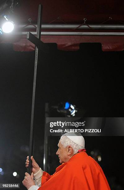 Pope Benedict XVI holds the Cross during the Way of the Cross on Good Friday on April 2, 2010 at Rome's Colosseum. AFP PHOTO / ALBERTO PIZZOLI