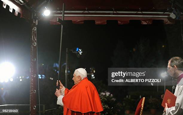 Pope Benedict XVI holds the Cross during the Way of the Cross on Good Friday on April 2, 2010 at Rome's Colosseum. AFP PHOTO / ALBERTO PIZZOLI