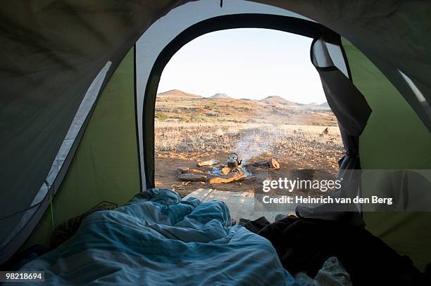 distant view of camp fire and scene, taken from within a tent, sesfontein, kaokoland, namibia - freek van den bergh stock pictures, royalty-free photos & images