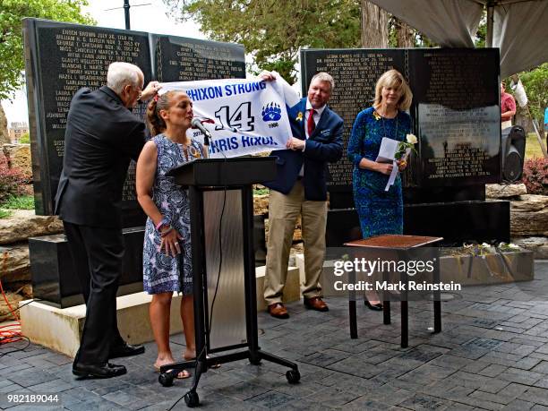 Natalie Hixon, the younger sister of slain Marjory Stoneman Douglas High School athletic director Chris Hixon, speaks as a flag she and her family...